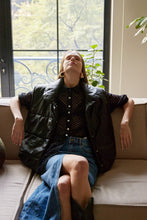 Cargar imagen en el visor de la galería, Chaleco Puffer en color Café. Diseño alcochado en cuero sintético. Tejido técnico repelente al agua. Cuello subido y sin mangas. Bolsillos laterales. Cierre frontal con botones a presión ocultos por la solapa. Forro interior con estampado de Flint. Disponible en color Café y Negro.. Productoo hecho en Colombia. Compra Online