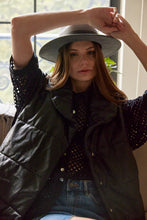 Cargar imagen en el visor de la galería, Chaleco Puffer en color Café. Diseño alcochado en cuero sintético. Tejido técnico repelente al agua. Cuello subido y sin mangas. Bolsillos laterales. Cierre frontal con botones a presión ocultos por la solapa. Forro interior con estampado de Flint. Disponible en color Café y Negro.. Productoo hecho en Colombia. Compra Online