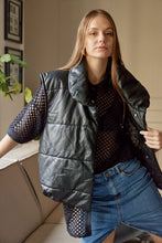 Cargar imagen en el visor de la galería, Chaleco Puffer en color Café. Diseño alcochado en cuero sintético. Tejido técnico repelente al agua. Cuello subido y sin mangas. Bolsillos laterales. Cierre frontal con botones a presión ocultos por la solapa. Forro interior con estampado de Flint. Disponible en color Café y Negro.. Productoo hecho en Colombia. Compra Online