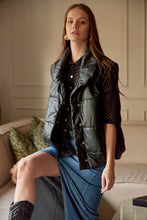 Cargar imagen en el visor de la galería, Chaleco Puffer en color Café. Diseño alcochado en cuero sintético. Tejido técnico repelente al agua. Cuello subido y sin mangas. Bolsillos laterales. Cierre frontal con botones a presión ocultos por la solapa. Forro interior con estampado de Flint. Disponible en color Café y Negro.. Productoo hecho en Colombia. Compra Online