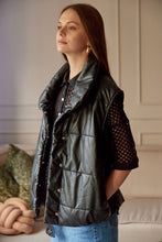 Cargar imagen en el visor de la galería, Chaleco Puffer en color Café. Diseño alcochado en cuero sintético. Tejido técnico repelente al agua. Cuello subido y sin mangas. Bolsillos laterales. Cierre frontal con botones a presión ocultos por la solapa. Forro interior con estampado de Flint. Disponible en color Café y Negro.. Productoo hecho en Colombia. Compra Online