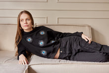 Cargar imagen en el visor de la galería, Saco con ojos de protección bordados. Tejido de algodón. Con detalle de ojos bordados. Diseño recto. Cuello redondo. Manga Larga. Cuello pretina y puños en rib tejido tono a tono. Disponible en color Negro. Porducto hecho en Colombia. Compra Online.