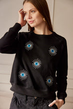 Cargar imagen en el visor de la galería, Saco con ojos de protección bordados. Tejido de algodón. Con detalle de ojos bordados. Diseño recto. Cuello redondo. Manga Larga. Cuello pretina y puños en rib tejido tono a tono. Disponible en color Negro. Porducto hecho en Colombia. Compra Online.