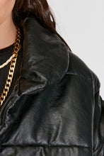 Cargar imagen en el visor de la galería, Chaqueta Puffer de mujer. Diseño alcochado en cuero sintético. Tejido técnico repelente al agua. Cuero Vegano. Cuello subido y manga larga con puños elásticos. Bolsillos laterales. Cierre frontal con botones a presión ocultos por la solapa. Forro interior con estampado de Flint. Disponible en color Café y Negro. Producto 100% hecho en Colombia.