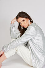 Cargar imagen en el visor de la galería, Chaqueta de Lentejuelas de mujer. Tejido de lentejuelas. Diseño largo y recto. Cuello redondo. Manga larga. Dos bolsillos laterales forrados en terciopelo. Forro interior en viscosa tono a tono. Detalles de terciopelo en la terminación de pretina, puños, cuello y frente. Colores Oro Rosa, Plateado y Negro. Producto 100% hecho en Colombia. Compra Online