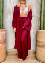 Cargar imagen en el visor de la galería, Sets de Verano para mujer. Tejido fluido liso. Composición: 100% rayón. Set de 2 Piezas. Kimono diseño recto, largo y manga tres cuartos. Pantalones Diseño wide leg, largo y de tiro alto. Bolsillos laterales. Cintura elástica. Sin cierre. Cordón decorativo con terminaciones en metal. Úsalo para ir de vacaciones como salida de baño, para ir a fiestas o eventos ó para días relajados y descomplicados. Disponible en color negro y vinotinto. Producto 100% hecho en Colombia.