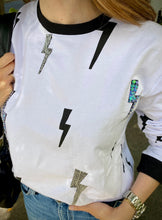 Cargar imagen en el visor de la galería, Saco de mujer. Tejido Algodón. Diseño estampado de rayos con intervenciones artesanales decorativas hechas a mano. Bordados en lentejuelas, perlas y puntadas. Diseño recto. Cuello redondo. Manga larga. Disponible en 2 colores, blanco y Negro. Estas prendas son productos que han sido confeccionadas con fibras y/o procesos de producción sostenible, reduciendo así su impacto ambiental. Producto hecho en Colombia. Compra Online