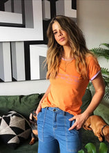 Cargar imagen en el visor de la galería, Camiseta setenteras Flint de mujer cuello redondo. Cool, retro y funky. Disponible en tallas S,M y L. 4 colores azul, rosada, lila y naranja, con rib de colores en cuello y mangas. Frases inspiradas en Paulina de la Mora de la serie Mexicana "La casa de las flores". Fabricada en algodón Peruano. Producto hecho en Colombia. Compra online