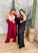 Cargar imagen en el visor de la galería, Sets de Verano para mujer. Tejido fluido liso. Composición: 100% rayón. Set de 2 Piezas. Kimono diseño recto, largo y manga tres cuartos. Pantalones Diseño wide leg, largo y de tiro alto. Bolsillos laterales. Cintura elástica. Sin cierre. Cordón decorativo con terminaciones en metal. Úsalo para ir de vacaciones como salida de baño, para ir a fiestas o eventos ó para días relajados y descomplicados. Disponible en color negro y vinotinto. Producto 100% hecho en Colombia.