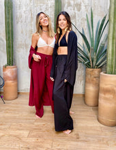 Cargar imagen en el visor de la galería, Sets de Verano para mujer. Tejido fluido liso. Composición: 100% rayón. Set de 2 Piezas. Kimono diseño recto, largo y manga tres cuartos. Pantalones Diseño wide leg, largo y de tiro alto. Bolsillos laterales. Cintura elástica. Sin cierre. Cordón decorativo con terminaciones en metal. Úsalo para ir de vacaciones como salida de baño, para ir a fiestas o eventos ó para días relajados y descomplicados. Disponible en color negro y vinotinto. Producto 100% hecho en Colombia.