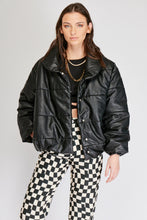 Cargar imagen en el visor de la galería, Chaqueta Puffer de mujer. Diseño alcochado en cuero sintético. Tejido técnico repelente al agua. Cuero Vegano. Cuello subido y manga larga con puños elásticos. Bolsillos laterales. Cierre frontal con botones a presión ocultos por la solapa. Forro interior con estampado de Flint. Disponible en color Café y Negro. Producto 100% hecho en Colombia.