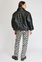 Cargar imagen en el visor de la galería, Chaqueta Puffer de mujer. Diseño alcochado en cuero sintético. Tejido técnico repelente al agua. Cuero Vegano. Cuello subido y manga larga con puños elásticos. Bolsillos laterales. Cierre frontal con botones a presión ocultos por la solapa. Forro interior con estampado de Flint. Disponible en color Café y Negro. Producto 100% hecho en Colombia.