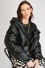 Cargar imagen en el visor de la galería, Chaqueta Puffer de mujer. Diseño alcochado en cuero sintético. Tejido técnico repelente al agua. Cuero Vegano. Cuello subido y manga larga con puños elásticos. Bolsillos laterales. Cierre frontal con botones a presión ocultos por la solapa. Forro interior con estampado de Flint. Disponible en color Café y Negro. Producto 100% hecho en Colombia.