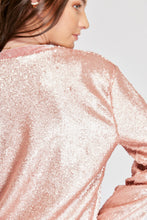 Cargar imagen en el visor de la galería, Chaqueta de Lentejuelas de mujer. Tejido de lentejuelas. Diseño largo y recto. Cuello redondo. Manga larga. Dos bolsillos laterales forrados en terciopelo. Forro interior en viscosa tono a tono. Detalles de terciopelo en la terminación de pretina, puños, cuello y frente. Colores Oro Rosa, Plateado y Negro. Producto 100% hecho en Colombia. Compra Online