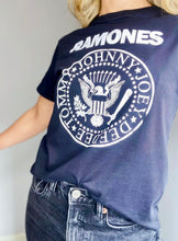 Cargar imagen en el visor de la galería, Camisetas básicas de mujer Glam Rock,rock and roll Disponible en tallas S, M y L.  Colores, blanca, negra y lila. Diamante de Flint bordado. Horma suelta. Fabricada en Algodón Peruano. Producto hecho en Colombia. Compra Online . Camisetas estampadas de mujer con grupos icónicos de rock como los rolling stones, los ramones y David Bowie
