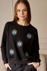 Saco con ojos de protección bordados. Tejido de algodón. Con detalle de ojos bordados. Diseño recto. Cuello redondo. Manga Larga. Cuello pretina y puños en rib tejido tono a tono. Disponible en color Negro. Porducto hecho en Colombia. Compra Online.