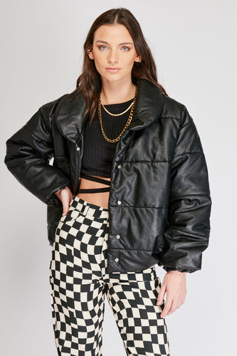 Chaqueta Puffer de mujer. Diseño alcochado en cuero sintético. Tejido técnico repelente al agua. Cuero Vegano. Cuello subido y manga larga con puños elásticos. Bolsillos laterales. Cierre frontal con botones a presión ocultos por la solapa. Forro interior con estampado de Flint. Disponible en color Café y Negro.  Producto 100% hecho en Colombia.