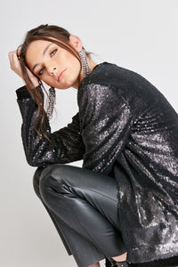 Chaqueta de Lentejuelas de mujer. Tejido de lentejuelas. Diseño largo y recto. Cuello redondo. Manga larga. Dos bolsillos laterales forrados en terciopelo. Forro interior en viscosa tono a tono. Detalles de terciopelo en la terminación de pretina, puños, cuello y frente. Colores Oro Rosa, Plateado y Negro. Producto 100% hecho en Colombia. Compra Online