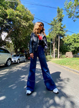 Cargar imagen en el visor de la galería, Jeans setenteros  de mujer Flint, bota campana. Tejido algodón. Modelo bota Campana. Tiro alto. Cuatro bolsillos. Cierre de cremallera y botón. Diseño azul oscuro y Bordado Happy y smiling face en uno de los bolsillos traseros. Producto 100% hecho en Colombia. Compra online

