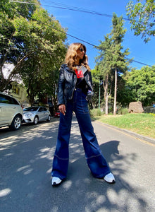 Jeans setenteros  de mujer Flint, bota campana. Tejido algodón. Modelo bota Campana. Tiro alto. Cuatro bolsillos. Cierre de cremallera y botón. Diseño azul oscuro y Bordado Happy y smiling face en uno de los bolsillos traseros. Producto 100% hecho en Colombia. Compra online