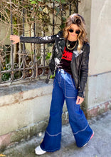Cargar imagen en el visor de la galería, Jeans setenteros  de mujer Flint, bota campana. Tejido algodón. Modelo bota Campana. Tiro alto. Cuatro bolsillos. Cierre de cremallera y botón. Diseño azul oscuro y Bordado Happy y smiling face en uno de los bolsillos traseros. Producto 100% hecho en Colombia. Compra online
