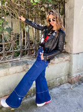 Cargar imagen en el visor de la galería, Jeans setenteros  de mujer Flint, bota campana. Tejido algodón. Modelo bota Campana. Tiro alto. Cuatro bolsillos. Cierre de cremallera y botón. Diseño azul oscuro y Bordado Happy y smiling face en uno de los bolsillos traseros. Producto 100% hecho en Colombia. Compra online
