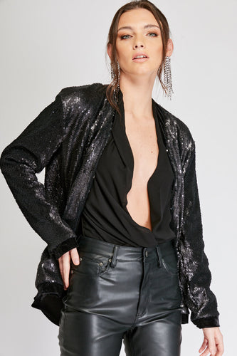 Chaqueta de Lentejuelas de mujer. Tejido de lentejuelas. Diseño largo y recto. Cuello redondo. Manga larga. Dos bolsillos laterales forrados en terciopelo. Forro interior en viscosa tono a tono. Detalles de terciopelo en la terminación de pretina, puños, cuello y frente. Colores Oro Rosa, Plateado y Negro. Producto 100% hecho en Colombia. Compra Online