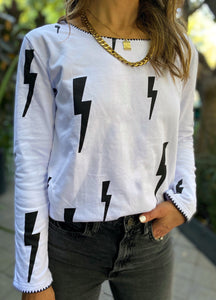 Saco de mujer. Tejido Algodón. Diseño estampado de rayos con bordado de puntadas hechas a mano en terminaciones de cuello y mangas. Diseño recto. Cuello redondo. Manga larga. Disponible en 2 colores, blanco y Negro.  Estas prendas son productos que han sido confeccionadas con fibras y/o procesos de producción sostenible, reduciendo así su impacto ambiental. Producto 100% hecho en Colombia. Compra Online